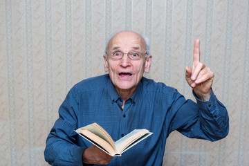 elderly man with a book in their hands lifted up a finger, there is an idea