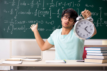 Young male student mathematician in front of chalkboard