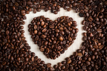  coffee beans on a wooden background in the form of a heart