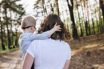 The family is going on a picnic in the forest. Mom, son. Summer walk. Picnic set. Dog. The kid with glasses.