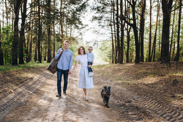 The family is going on a picnic in the forest. Mom, dad, son. Su