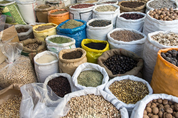 open bags with spices, nuts and beans in shop