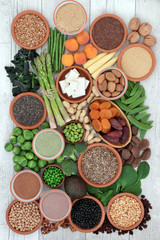 High protein super food with fresh vegetables, tofu, dried fruit, legumes, nuts, supplement powders, grains and seeds, high in dietary fibre, antioxidants and vitamins. Top view.