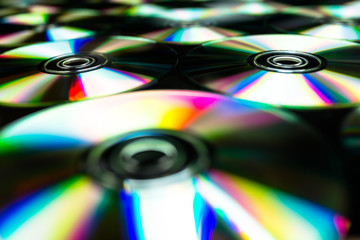 CDs / DVDs lying on a black background with reflections of light.