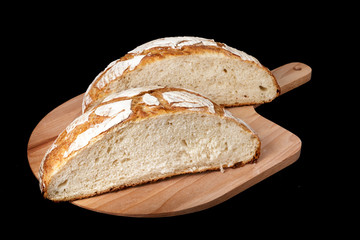 Handmade yeast-free bread on black background. Angle horizontal view.