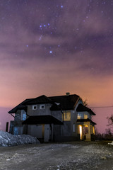 Gray house with black roof under cloudy winter night