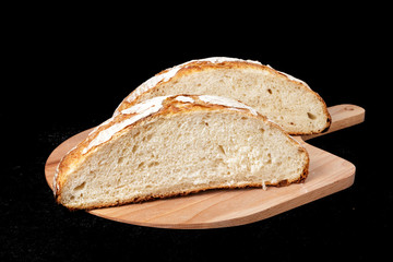 Handmade yeast-free bread on black background. Angle horizontal view.