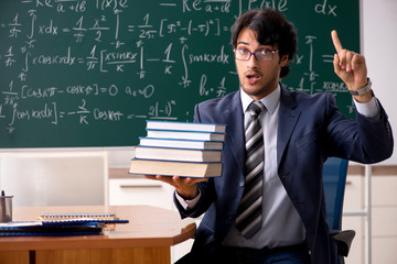 Young male math teacher in classroom