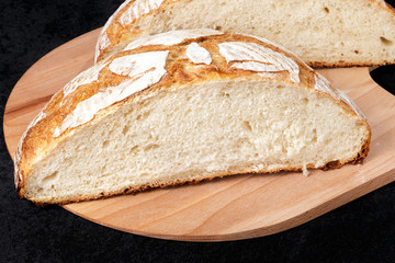 Handmade yeast-free bread on black background. Angle horizontal view.