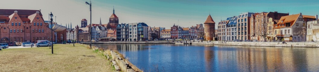 Fototapeta na wymiar panorama Gdańska, widok z wyspy Ołowianka na Motławę, wieże kościoła Mariackiego, filharmonię i basztę Łabędź