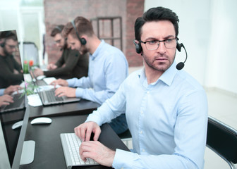 serious businessman in a headset sitting at a Desk