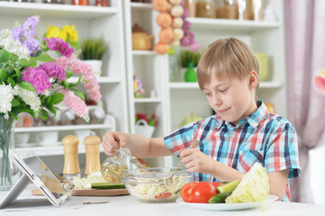 Portrait of cute little boy making dinner