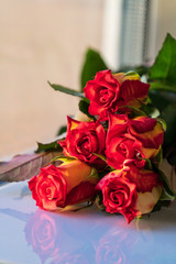 Bouquet of beautiful roses on a windowsill, day light.