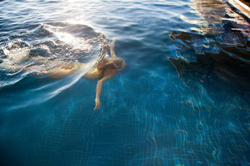 Woman swimming under water - obrazy, fototapety, plakaty