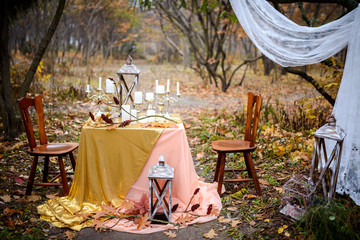 Vintage table with candles in the autumn forest. Wedding table. Autumn wedding