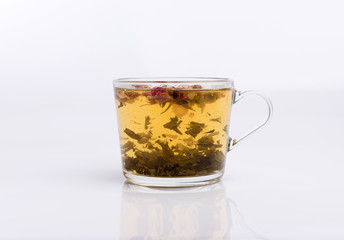 Glass cup of hot aromatic roses tea on white background