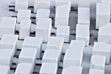 Apuan Alps, Carrara, Tuscany. White Carrara marble blocks in a warehouse. The blocks of white Carrara marble, after being extracted from the quarry, are deposited in outdoor squares.