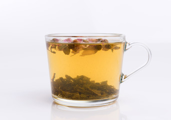 Glass cup of green tea with roses. Isolated on white background