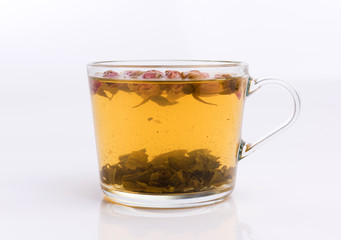 Glass cup of green tea with roses. Isolated on white background