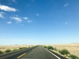 Fototapeta premium A photo showing an empty asphalt road in a desert climate, made sunny on a clear day.