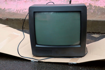 Broken old lamp tv at the concrete wall in the garbage