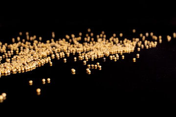 Lot of whole small white mustard seeds isolated on black glass