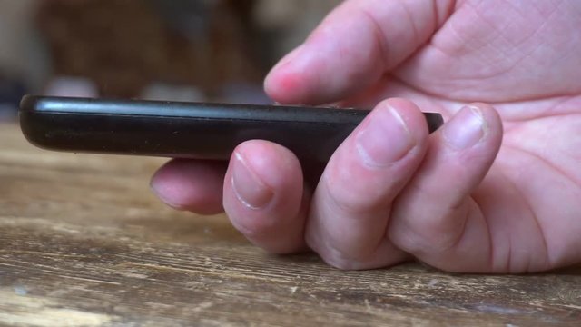 outdated push button mobile phone in hand.finger presses the phone buttons.close-up