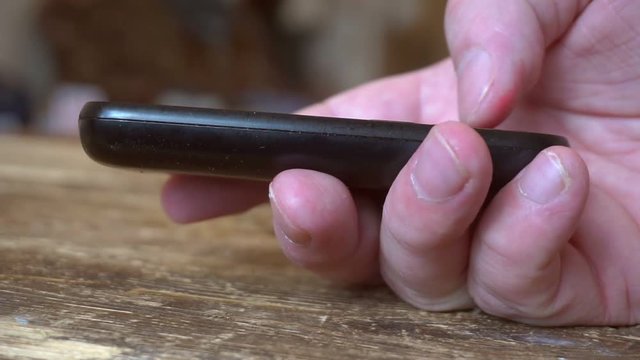 outdated push button mobile phone in hand.finger presses the phone buttons.close-up