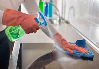 Woman cleaning induction stove in kitchen