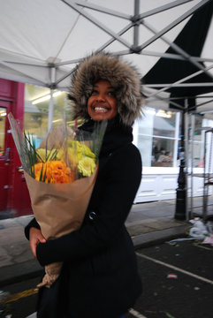 Young beautiful African woman showing excitement after receiving bouquet of flowers
