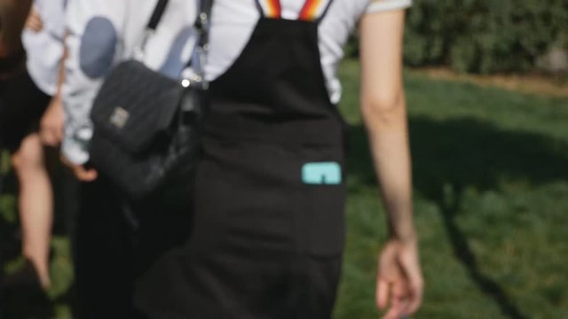 The girl goes forward with the phone in the back pocket of the skirt