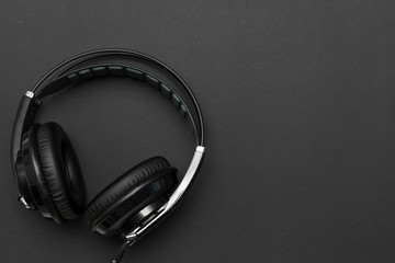 Close-up of black headphones for listening and mixing music on black background. Top view