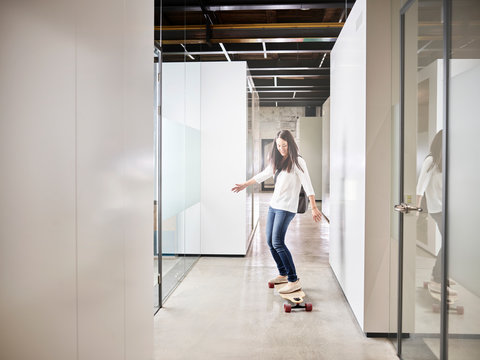 Woman Riding Longboard On Office Floor