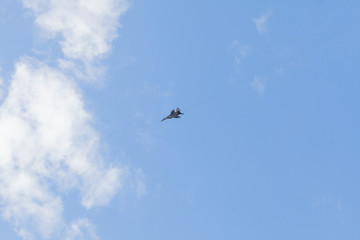 Military fighter in the blue sky with white clouds