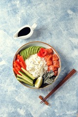 Sushi bowl with rice, salmon, avocado, cucumber, sweet pepper, ginger and sesame. Healthy food.