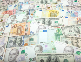 Money and finances concept. One hundred dollar new bill on colorful abstract background of Ukrainian, American and euro national currency banknotes