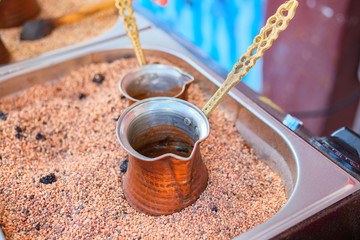 Preparation coffee in cezve on hot sand.