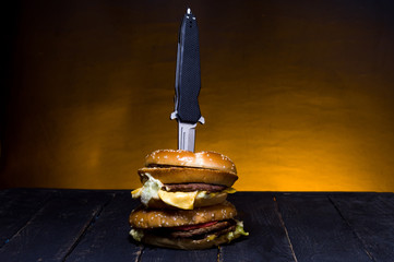A pocket knife in a burger. Folding knife and burger.