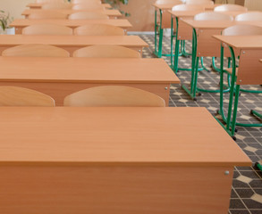 Interior of empty classroom with chairs and desks in a row