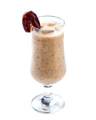 Yellow date smoothie in a tall glass decorated with dates on an isolated white background
