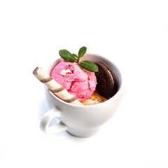 Ice cream decorated with mint and sweets in a cup on an isolated white background