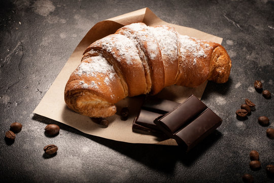 Single croissant and chocolate close up on table
