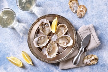 Fresh ocean oysters with slices of lemon on ice. 