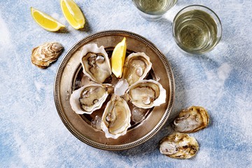 Fresh ocean oysters with slices of lemon on ice. 