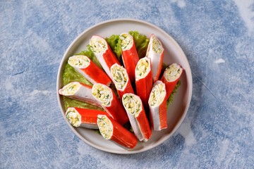 Crab sticks stuffed with soft cheese, boiled egg, garlic, mayonnaise and dill. Festive Russian snack. Top view. 