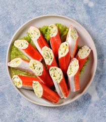 Crab sticks stuffed with soft cheese, boiled egg, garlic, mayonnaise and dill. Festive Russian snack. Top view. 