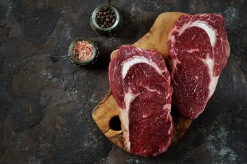 Raw fresh beef steak rib eye on old wooden background. Rustik Style. Top view.