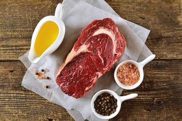 Raw fresh beef steak rib eye on old wooden background. Rustik Style. Top view.