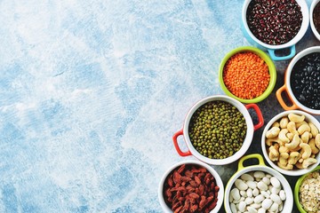 Red lentils, peas, black, white and red beans, nuts - the concept of healthy vegetarian food. Top view. 