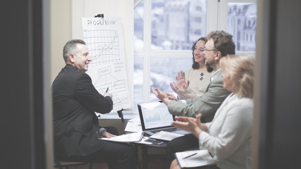 business partners applauding at the presentation of a new financ